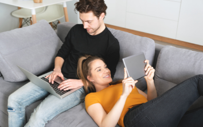 Couple at home on smart devices