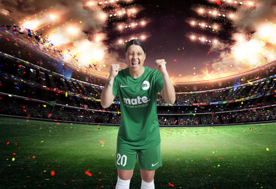 Soccer Captain stands on the field of a stadium that is being showered with confetti and fireworks. She is wearing a soccer uniform with the MATE logo.